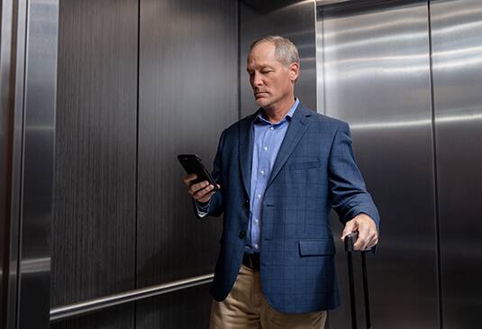 img_man-on-phone-kone-dx-elevator-535x365